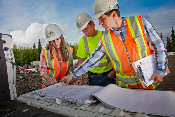UA construction management students look at plans at a job site with an Alaskan contractor 